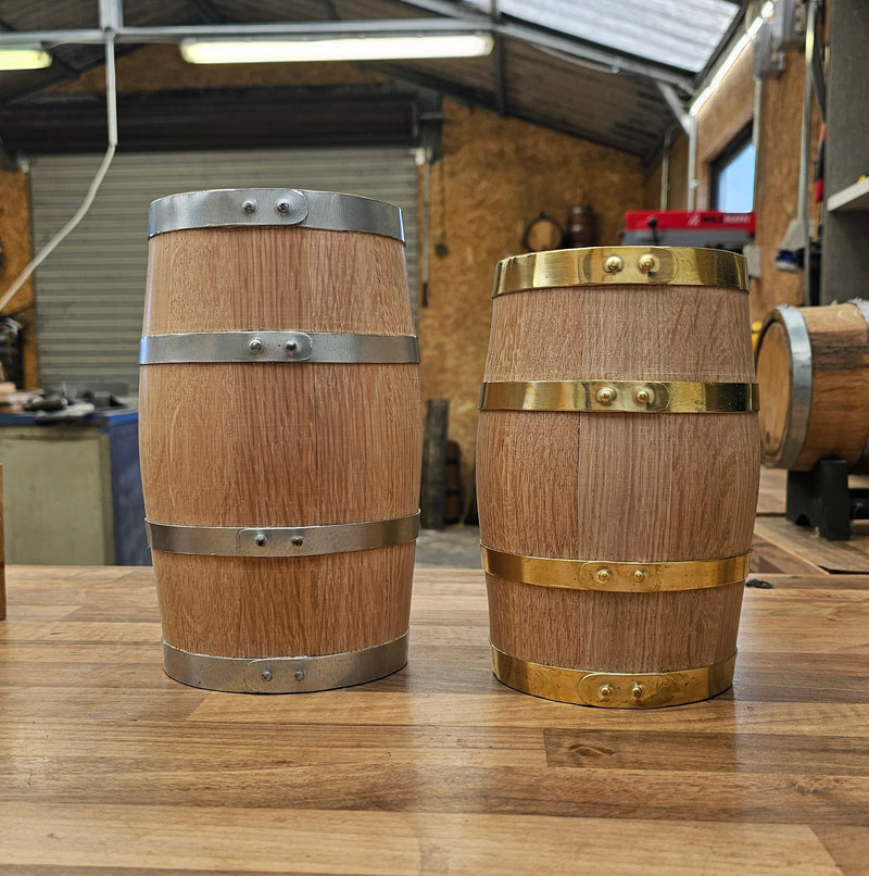 Wooden oak miniature barrels. One with steel hoops and the other with brass hoops.
