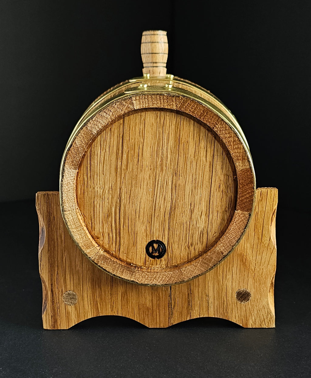 Wooden oak miniature barrel with brass hoops and tap. View from the back of cask. Tap isn't visible but makers mark: OMCC stamp is. Handcrafted in Cork, Ireland by O'Mahony Craft Cooperage.