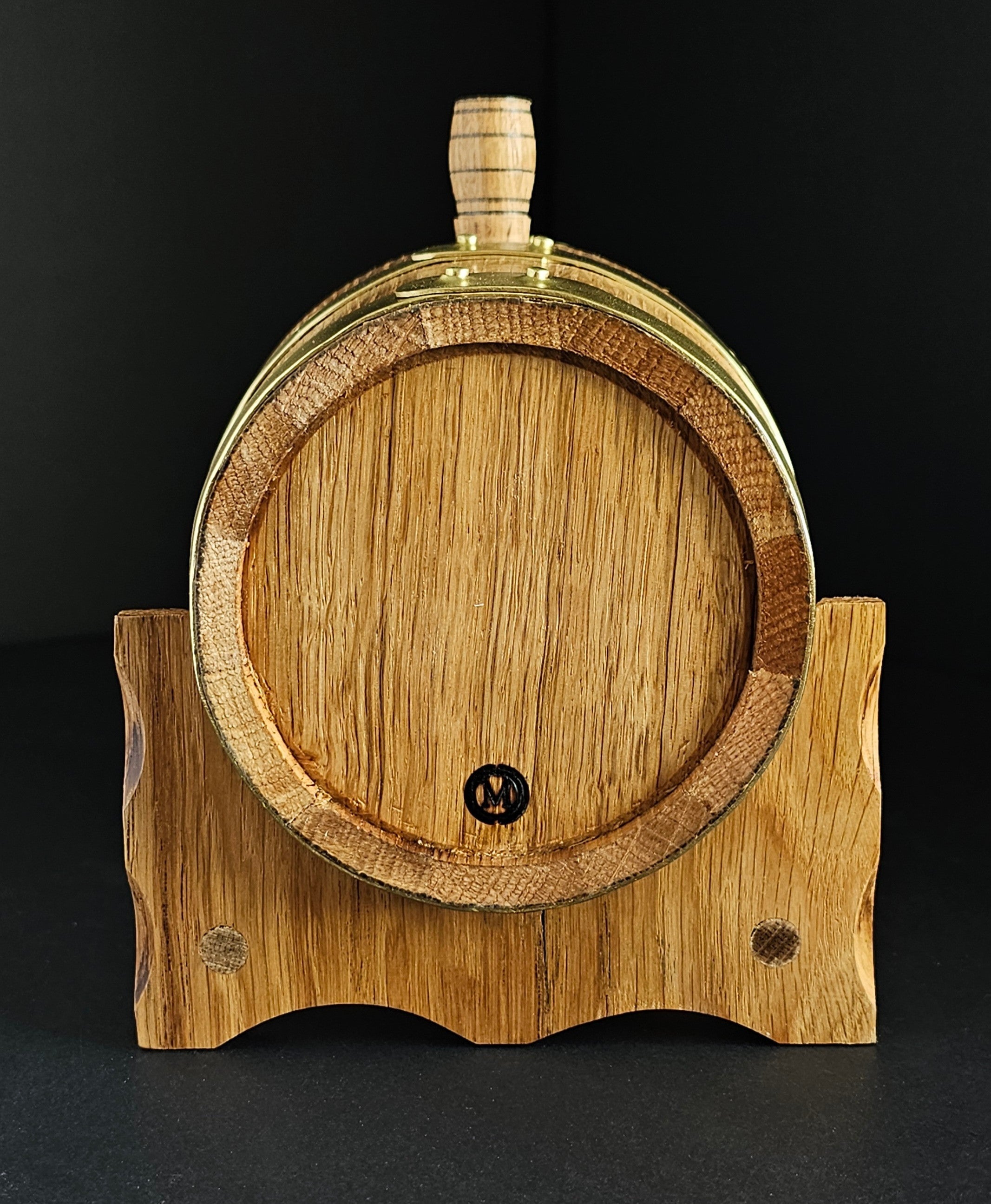 Wooden oak miniature barrel with brass hoops and tap. View from the back of cask. Tap isn't visible but makers mark: OMCC stamp is. Handcrafted in Cork, Ireland by O'Mahony Craft Cooperage.