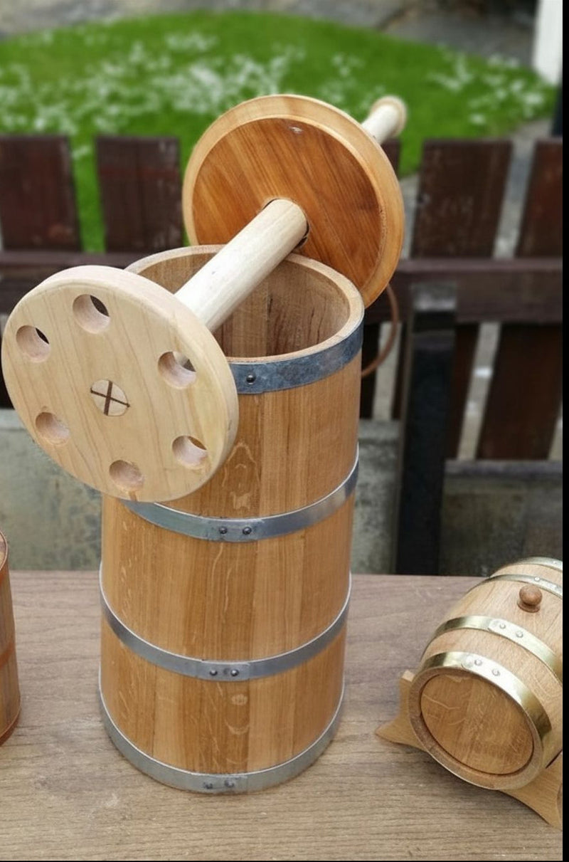 Coopered wooden oak butter churn open to show plunger. Flanked by a miniature barrel with brass hoops.
