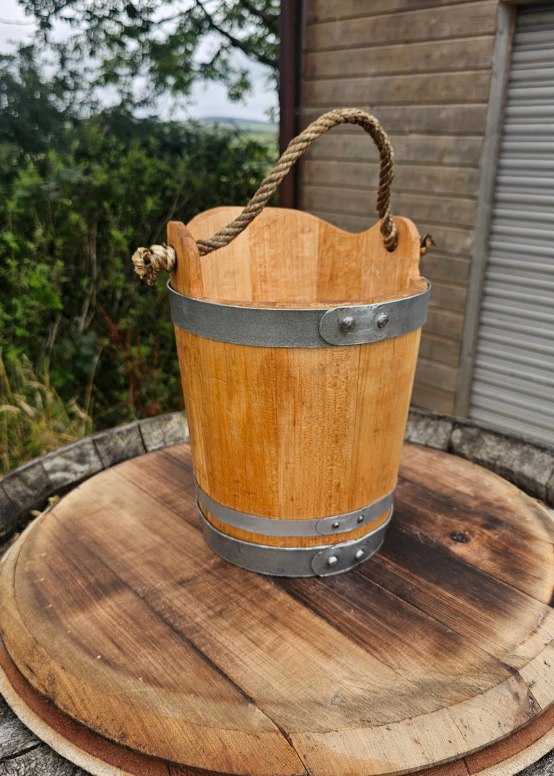 Wooden pail with steel hoops and rope handle