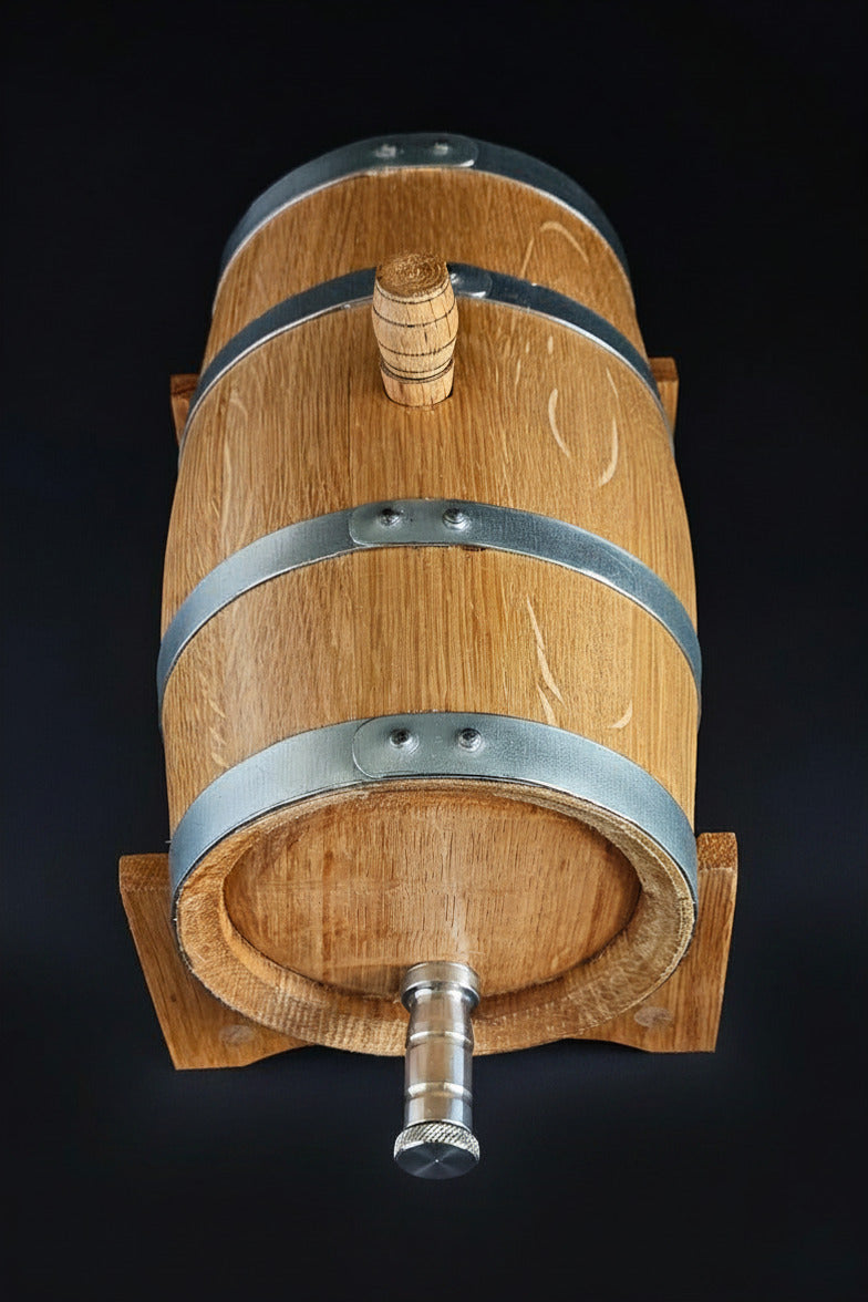 Wooden oak miniature barrel with steel tap and hoops. Top down view. Black background. Handcrafted in Cork, Ireland by O'Mahony Craft Cooperage.