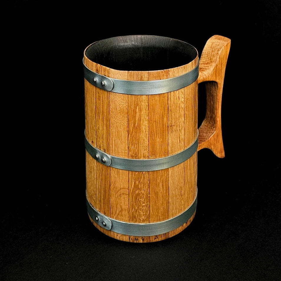 Wooden oak tankard with wooden handle and steel hoops and black background