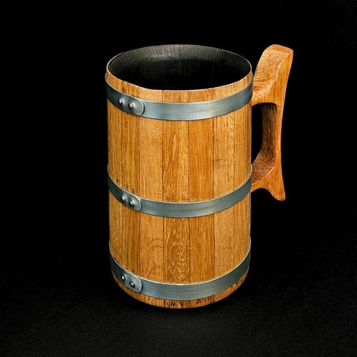 Wooden oak tankard with wooden handle and steel hoops and black background